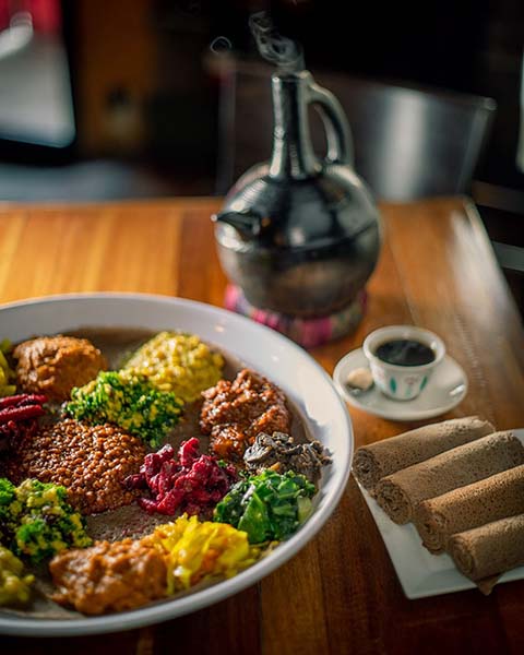 A spread of Ethiopian food with injera on the side.