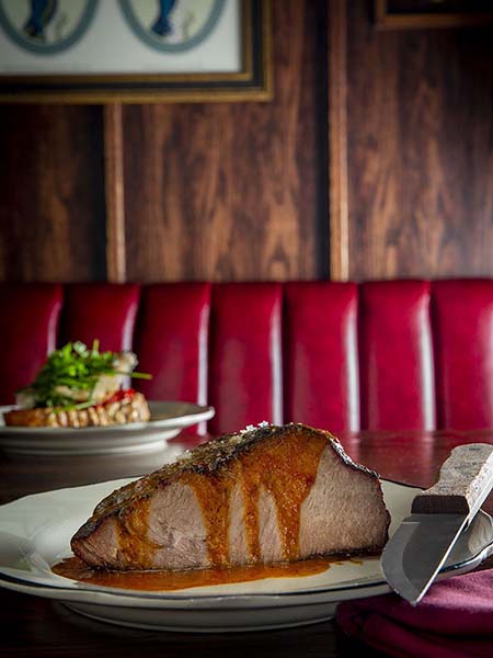 A gigantic slab of meat dripping in sauce at the underground restaurant Holy Ground in Tribecca.