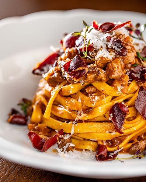 A closeup of pasta covered in bacon.